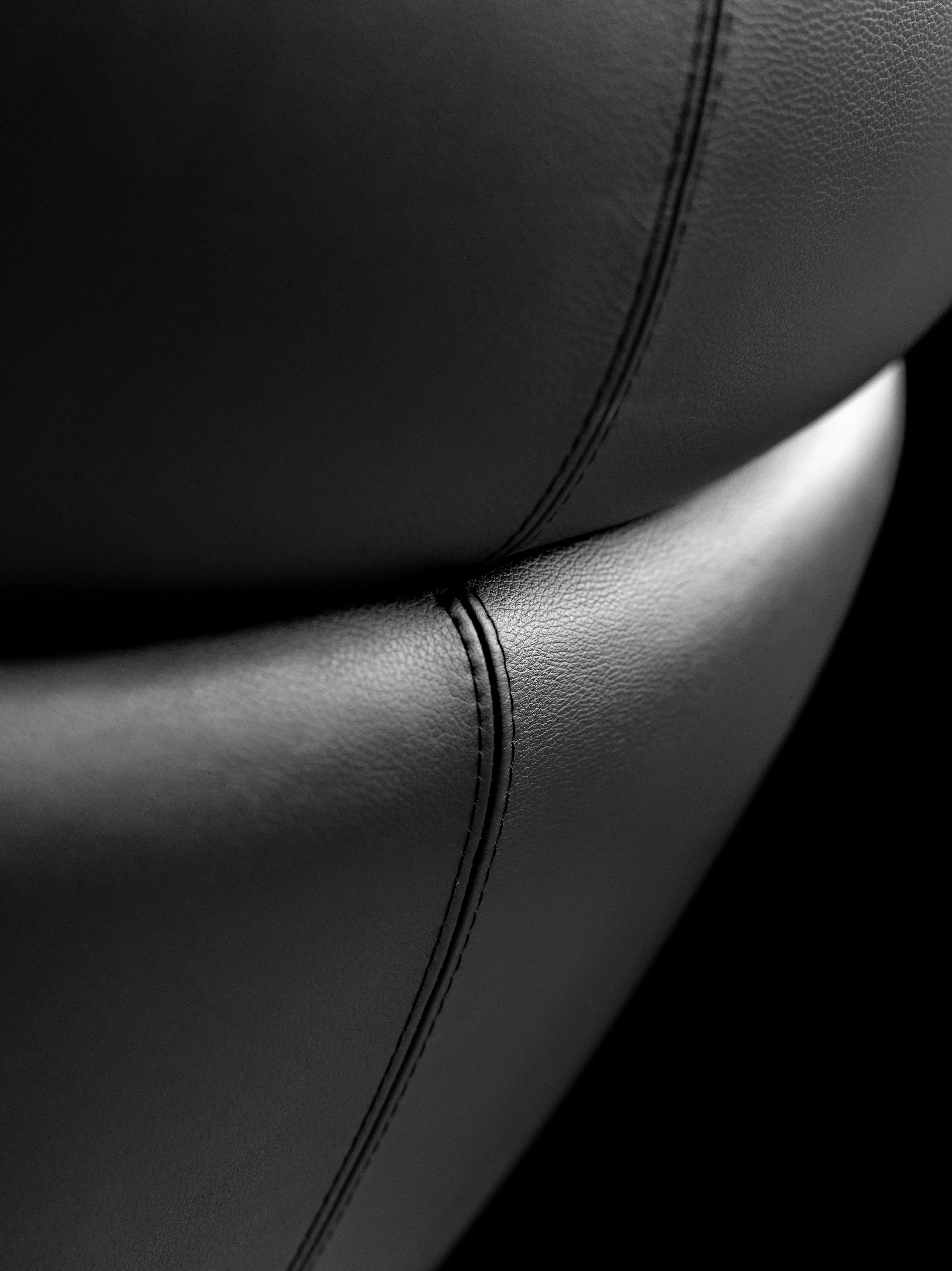 Close-up of black leather upholstery with visible stitching